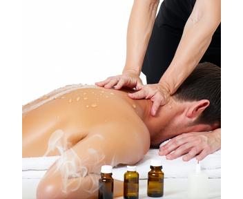 Praticienne effectuant un massage du dos avec huiles essentielles